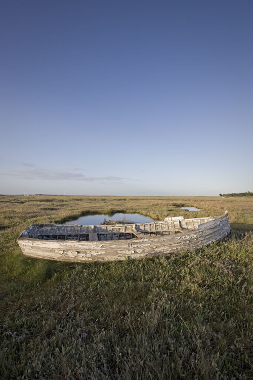 An old boat resting outside a fishing port in Brancaster Staithe, Norfolk